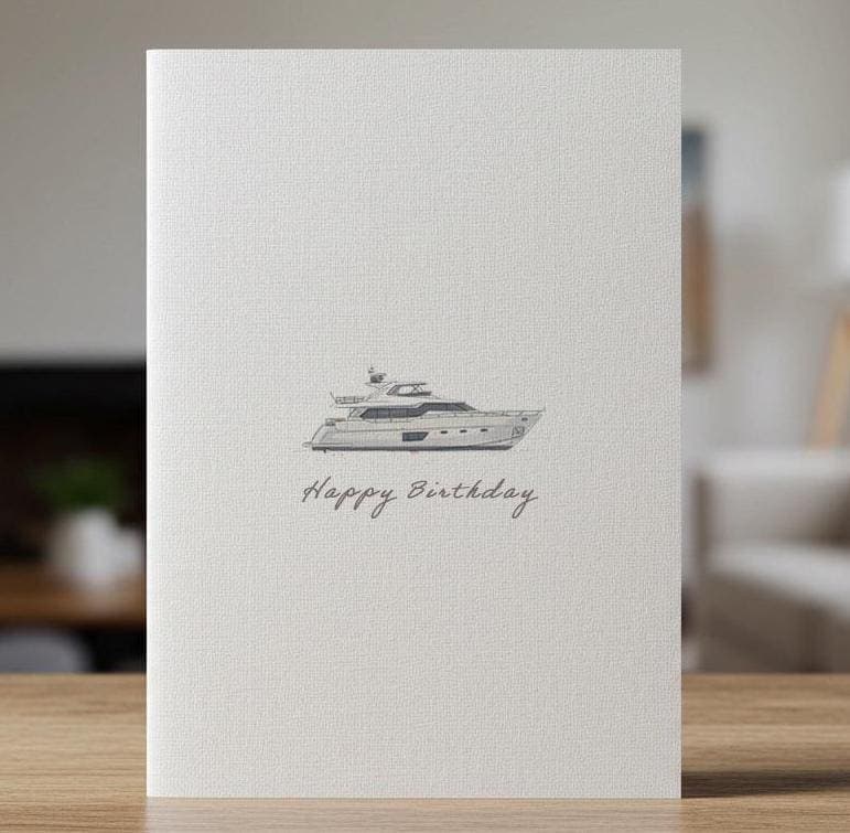 Linen birthday card with a watercolour yacht under sail, standing on a wooden surface
